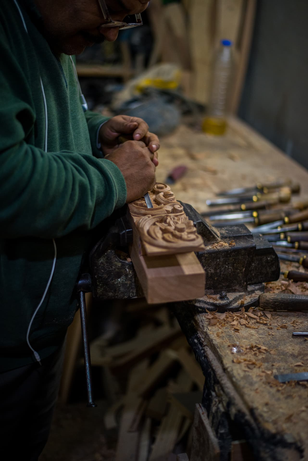 Craftsman hand carving a beech ornament at the workbench